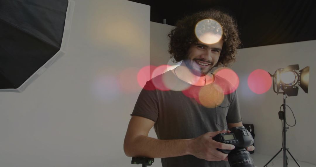 Smiling Photographer Holding DSLR in Professional Studio Setting