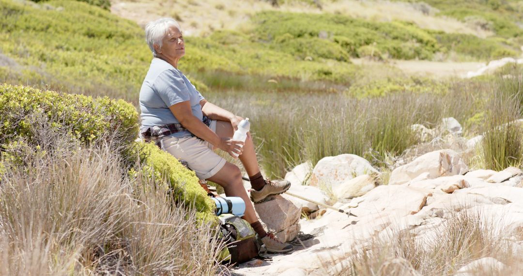 Elderly Woman Resting During Hike in Countryside - Free Images, Stock Photos and Pictures on Pikwizard.com