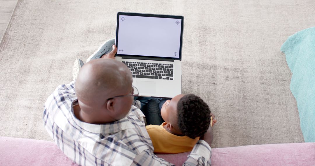 Grandfather and Grandson Using Laptop Together at Home - Free Images, Stock Photos and Pictures on Pikwizard.com