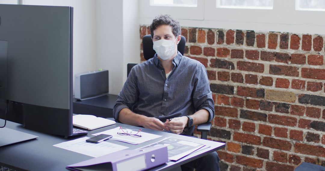 Office Worker Wearing Mask at Desk During Pandemic - Free Images, Stock Photos and Pictures on Pikwizard.com