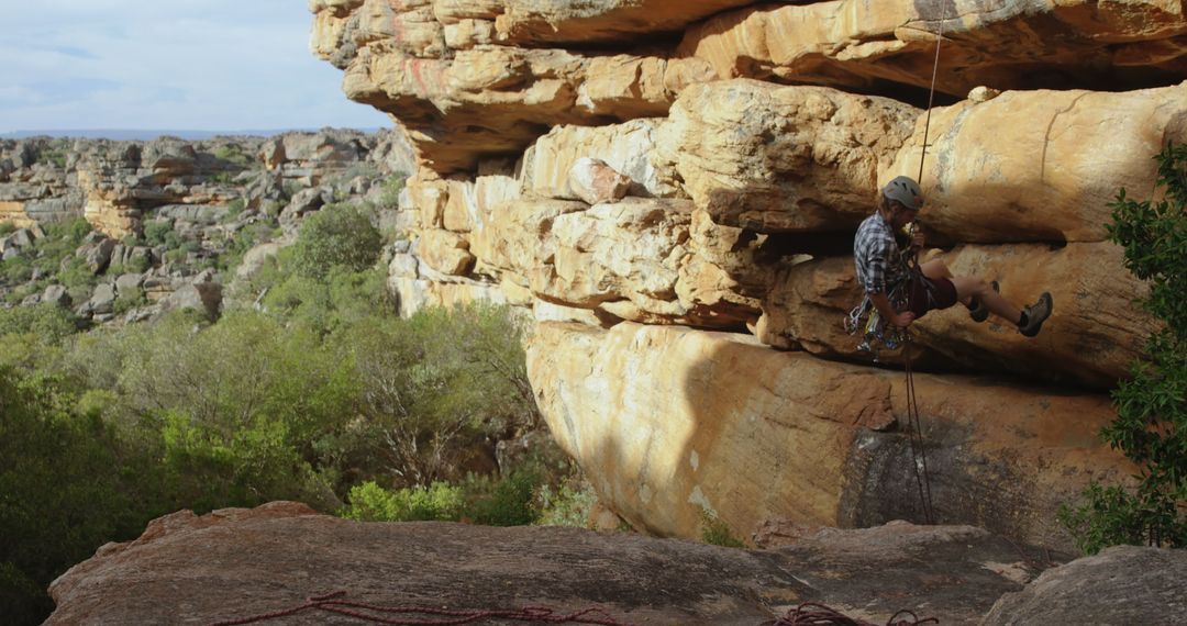 Male Rock Climber Rappelling Down Sunny Cliff Face - Free Images, Stock Photos and Pictures on Pikwizard.com