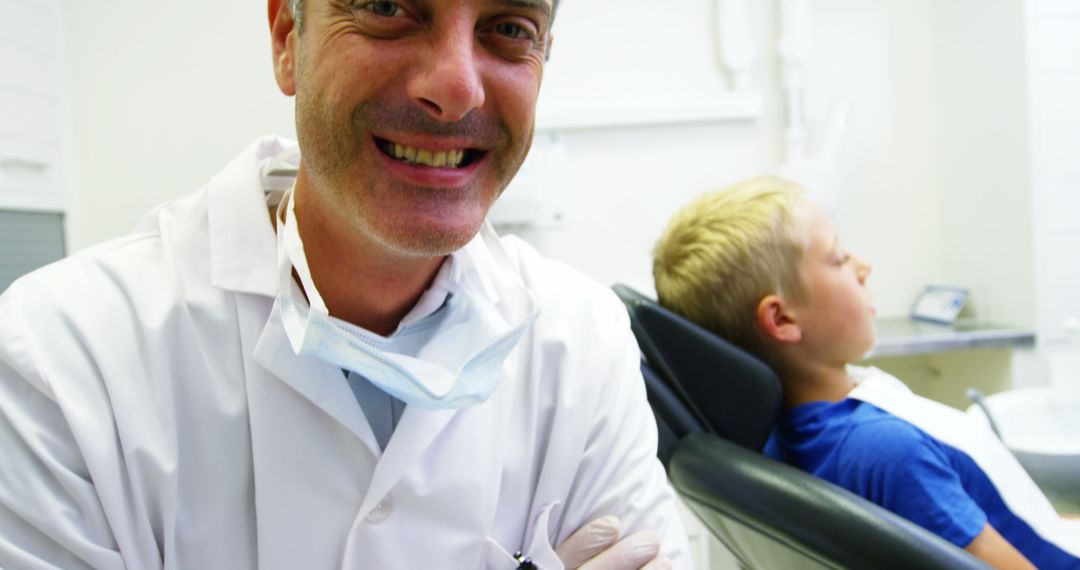 Smiling Dentist with Young Patient in Background - Free Images, Stock Photos and Pictures on Pikwizard.com