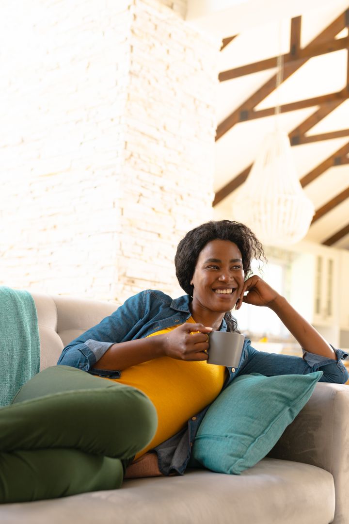 Cheerful African American Woman Relaxing with Coffee at Home - Free Images, Stock Photos and Pictures on Pikwizard.com