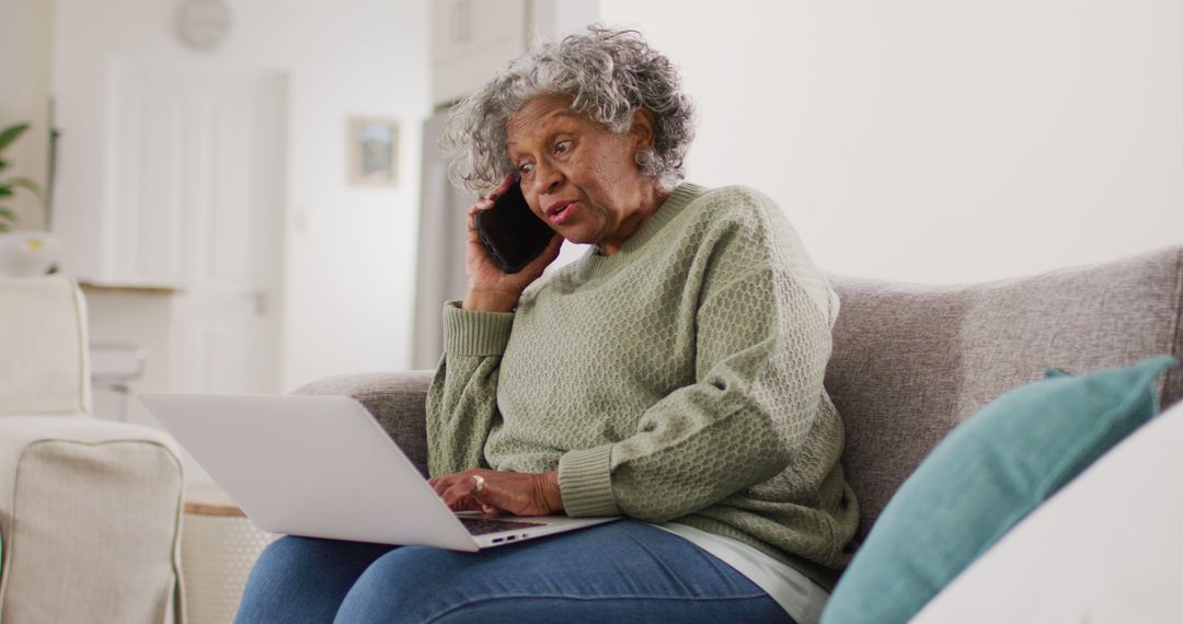 Elderly Woman Using Laptop and Talking on Mobile Phone at Home - Free Images, Stock Photos and Pictures on Pikwizard.com