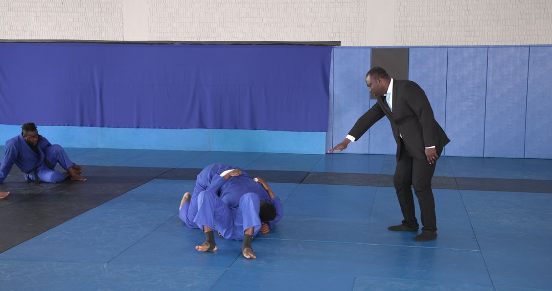 Grappling Training Guided by Instructor in Martial Arts Dojo