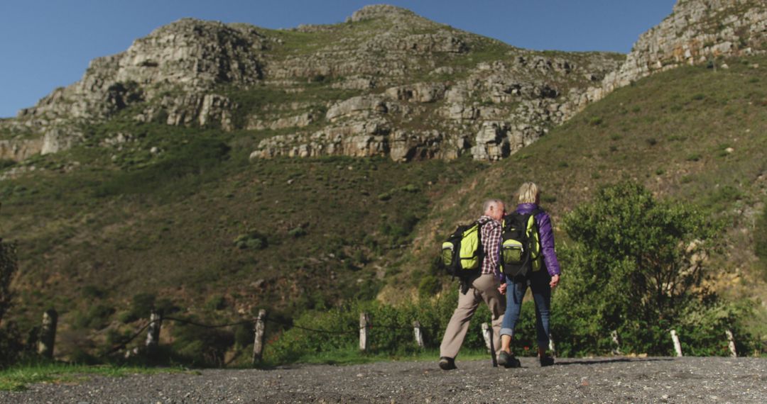 Senior Couple Hiking in Mountain Range on a Clear Day - Free Images, Stock Photos and Pictures on Pikwizard.com