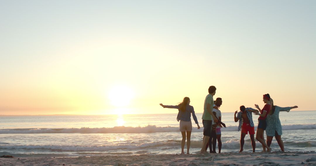 Friends Enjoying Beach Sunset with Open Sky and Ocean Waves