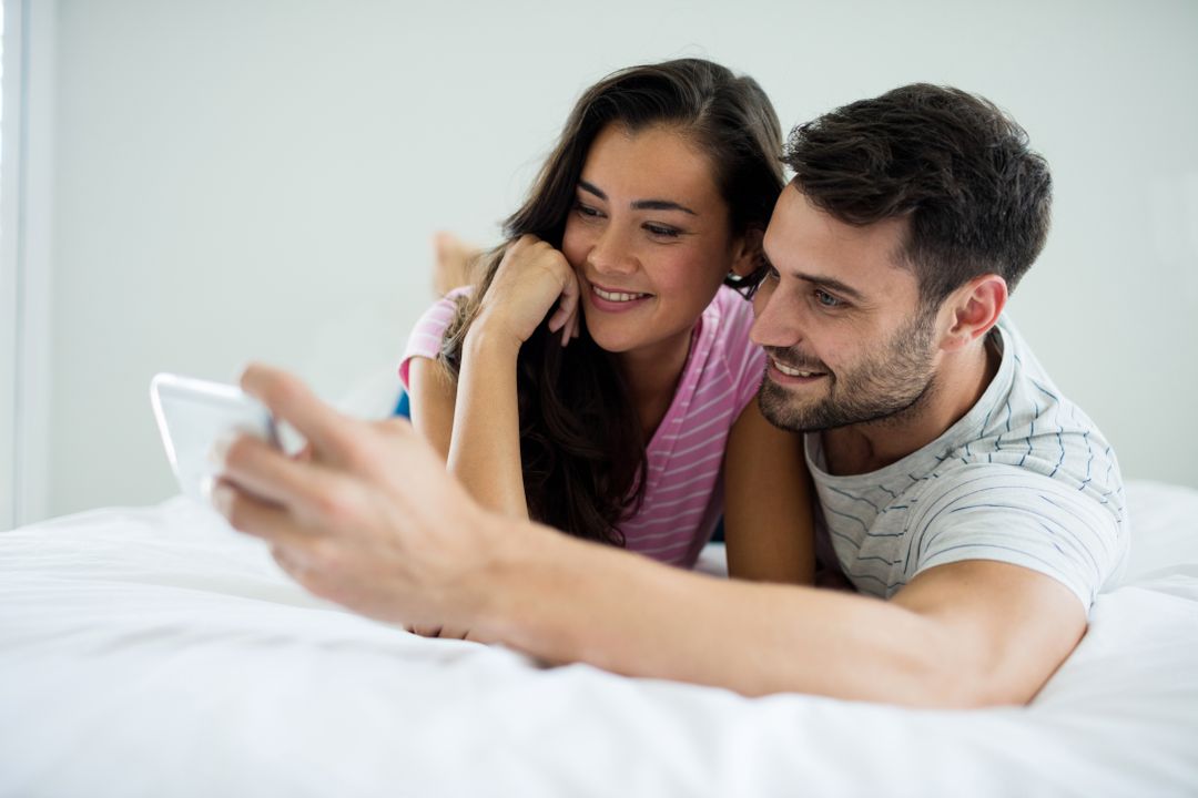 Happy Couple Taking Selfie in Bedroom - Free Images, Stock Photos and Pictures on Pikwizard.com