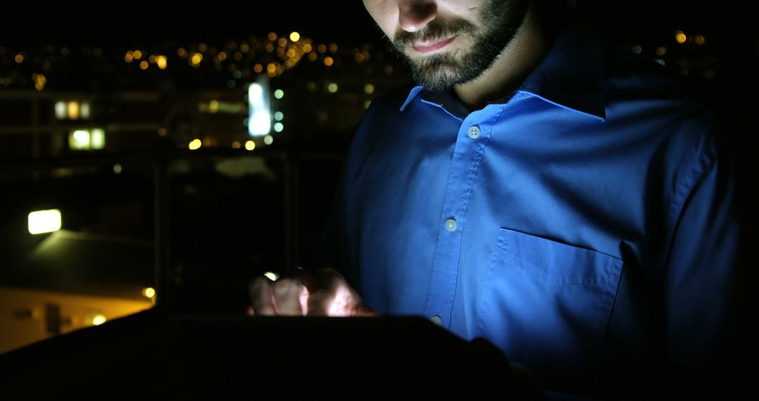 Man Using Tablet at Night with City Lights in Background - Free Images, Stock Photos and Pictures on Pikwizard.com