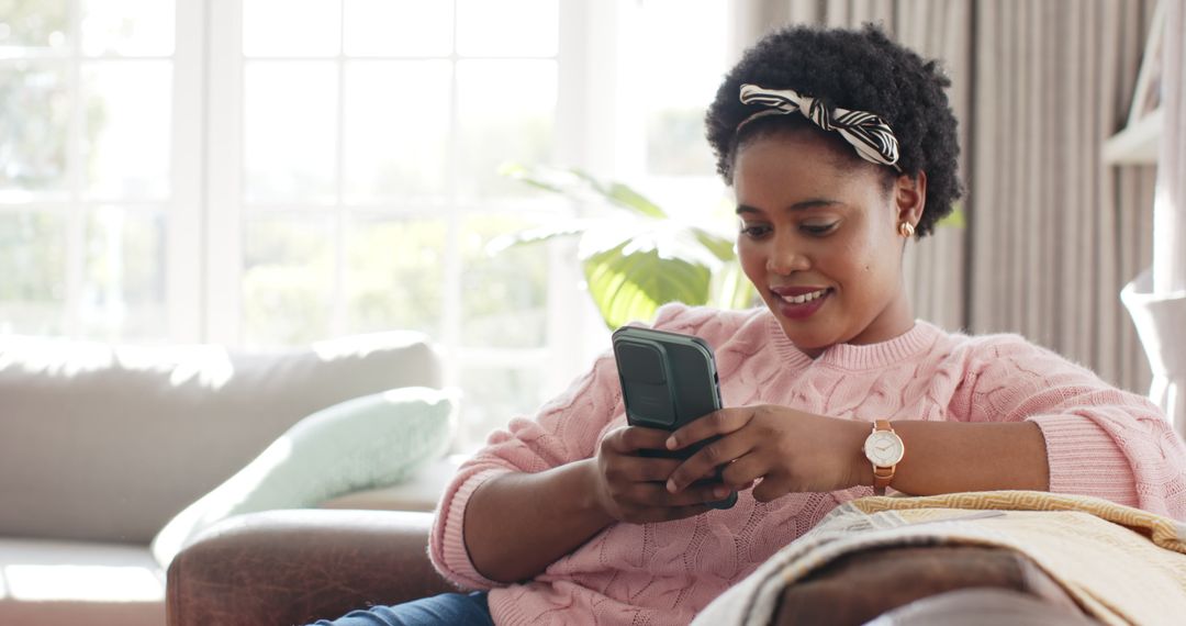Joyful Woman Relaxing with Smartphone at Home