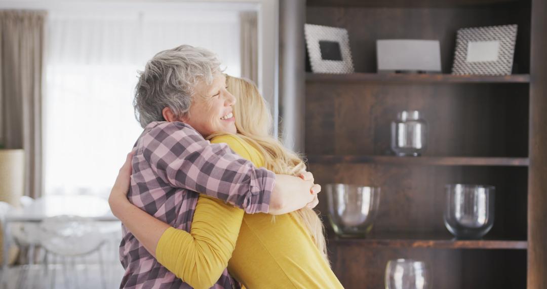 Senior woman hugging young family member in cozy home - Free Images, Stock Photos and Pictures on Pikwizard.com