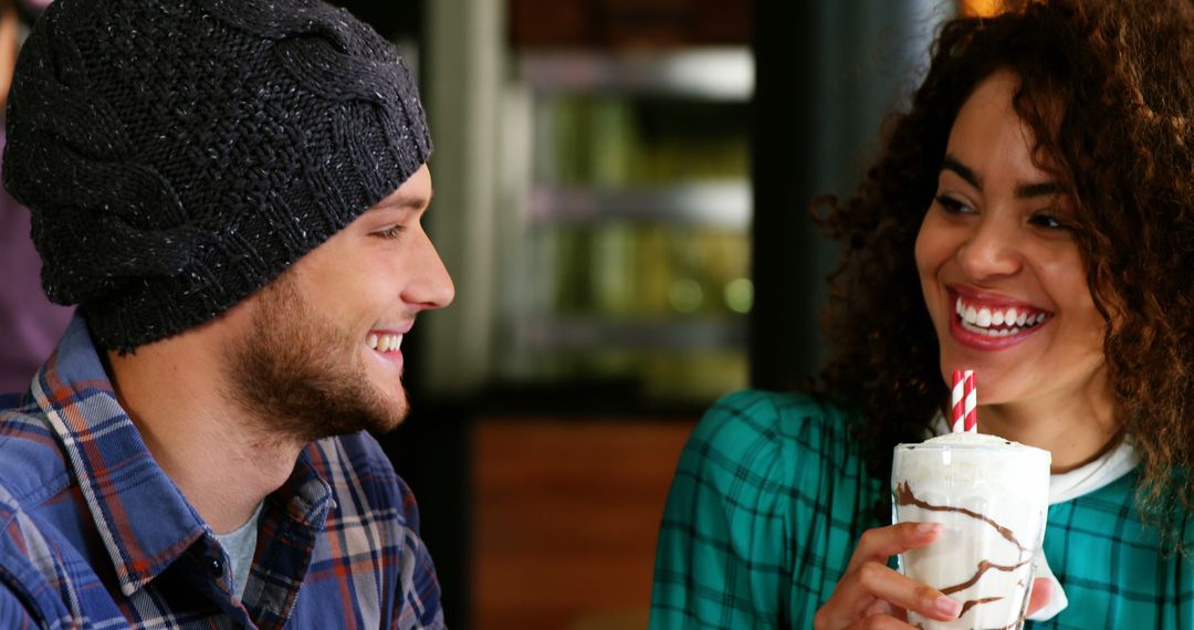 Interracial Friends Enjoying Milkshake in Cozy Cafe