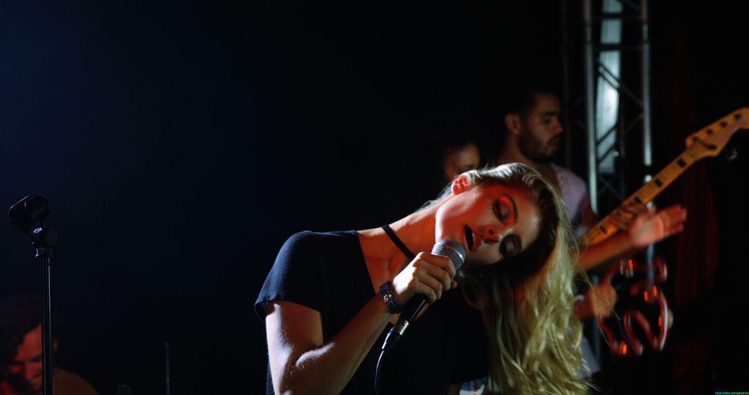 Young Female Singer Performing on Stage with Live Band
