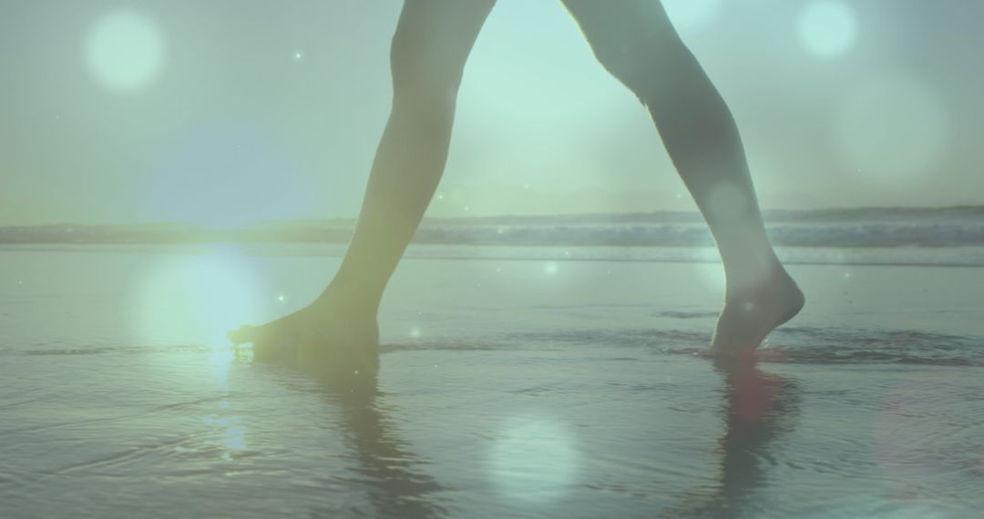 Person Walking on Beach at Sunset with Light Flares - Free Images, Stock Photos and Pictures on Pikwizard.com