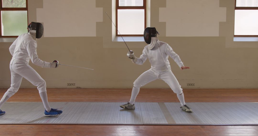 Two Male Fencers in Action Posing with Foils