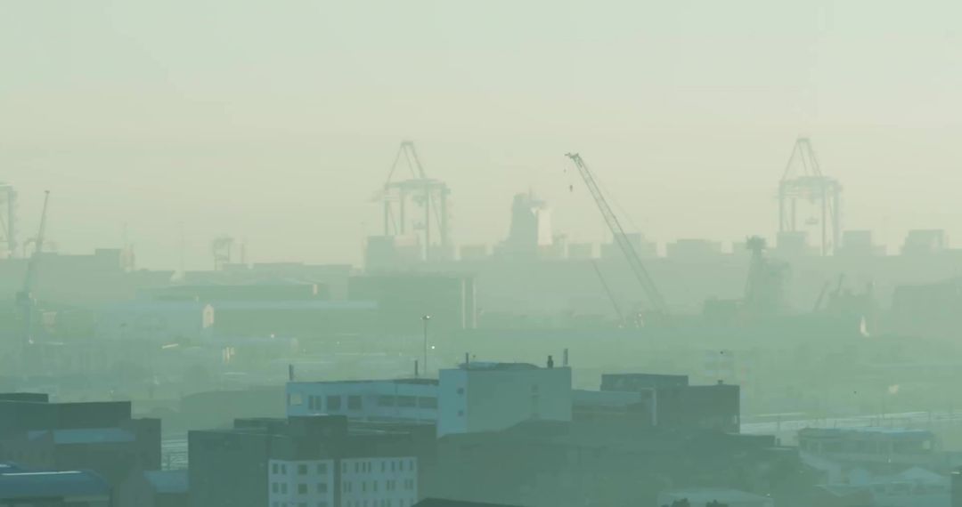 Container Cranes Over Port City Skyline in Hazy Smog