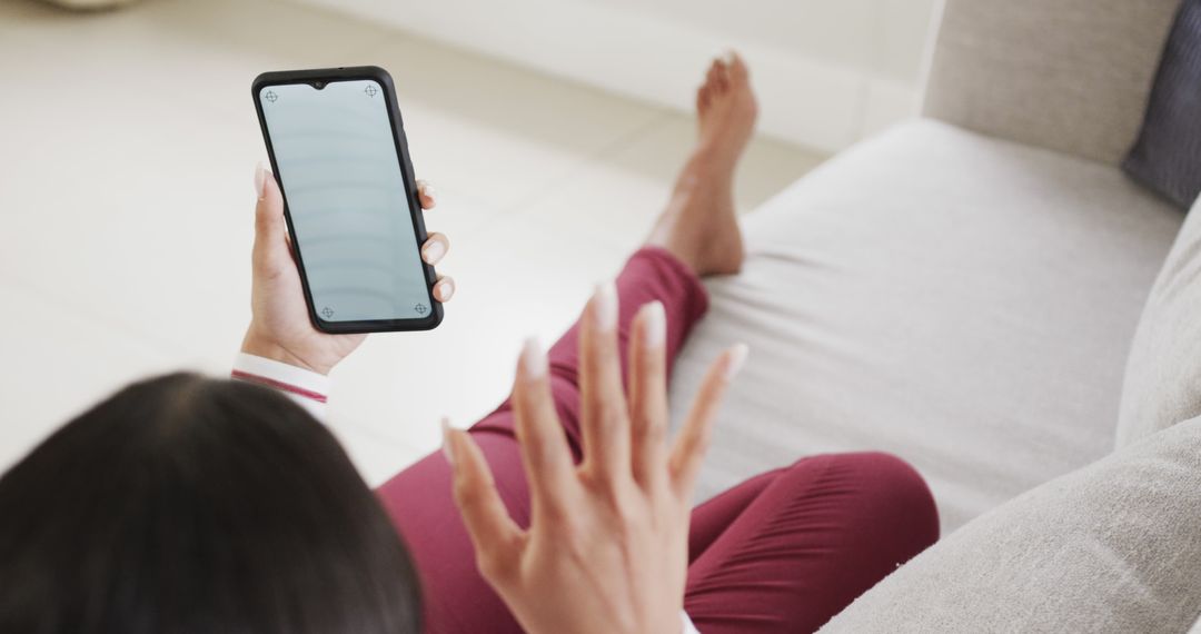 Woman Relaxing on Sofa Using Smartphone with Blank Screen - Free Images, Stock Photos and Pictures on Pikwizard.com