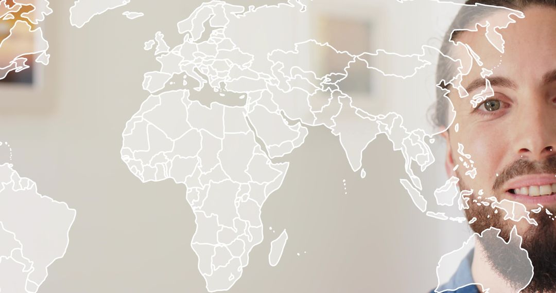 Bearded man with nose piercing looking past world map overlay for global business concept