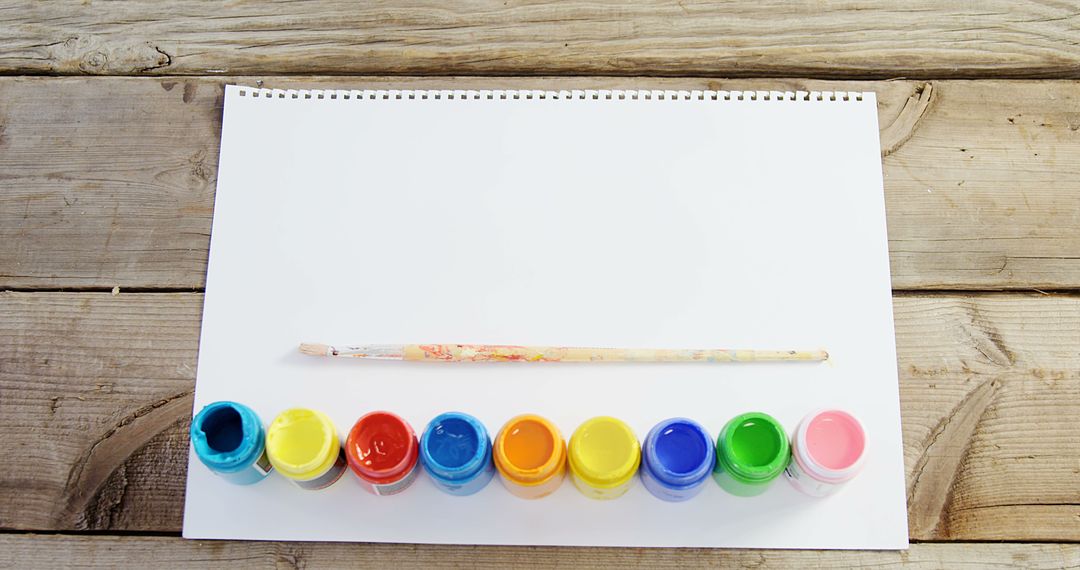 Blank Sheet with Colorful Paint Pots and Brush on Wooden Table - Free Images, Stock Photos and Pictures on Pikwizard.com