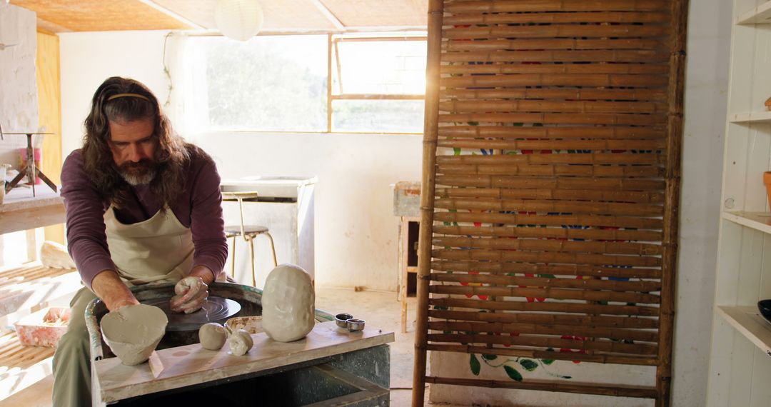 Male Potter Shaping Clay on Pottery Wheel in Rustic Studio - Free Images, Stock Photos and Pictures on Pikwizard.com