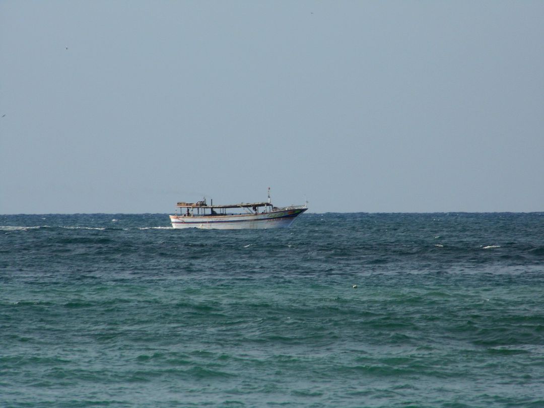 Fishing Boat in the Distance on a Calm Ocean - Free Images, Stock Photos and Pictures on Pikwizard.com