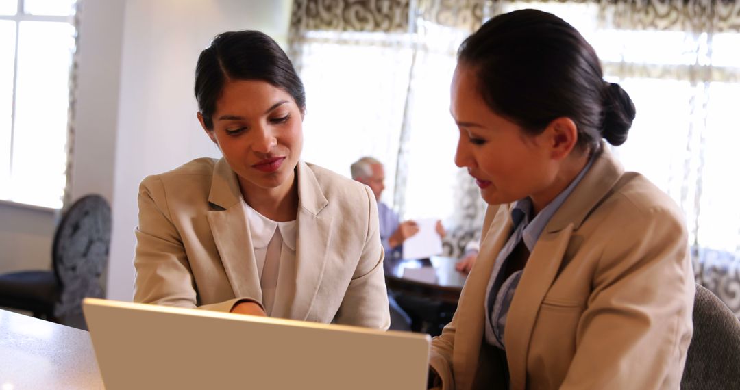 Professional Businesswomen Collaborating at Cafeteria