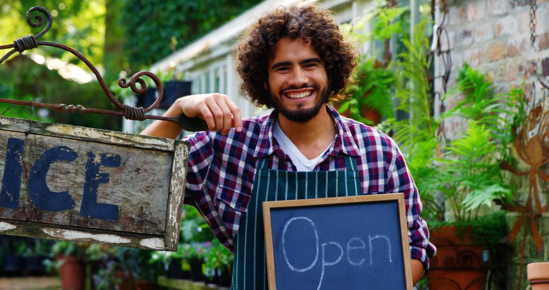 Smiling Gardener Welcoming Customers in Greenhouse