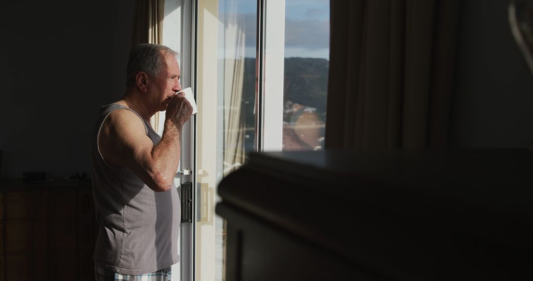 Elderly Man Sipping Coffee by Sunlit Window in Early Morning - Free Images, Stock Photos and Pictures on Pikwizard.com