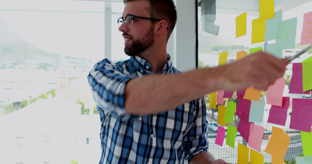 Young Professional Brainstorming with Sticky Notes in Office