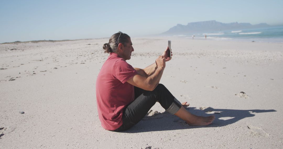 Man Taking Photos With Smartphone on Secluded Beach - Free Images, Stock Photos and Pictures on Pikwizard.com