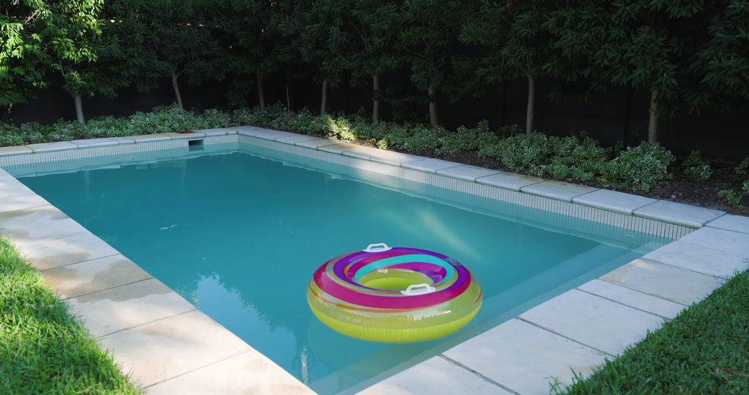 Inflatable Pool Ring Floating in Backyard Swimming Pool on Sunny Day