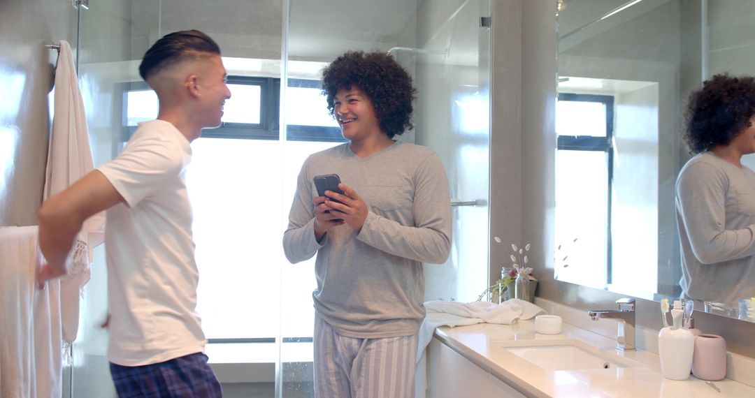 Diverse Friends Sharing Moment in Modern Bathroom While Checking Smartphone