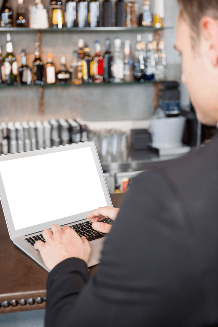 Businessman using Laptop in Modern Transparent Cafe Interior