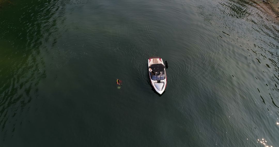 Aerial View of Motorboat on Calm Water with Swimmer Nearby - Free Images, Stock Photos and Pictures on Pikwizard.com