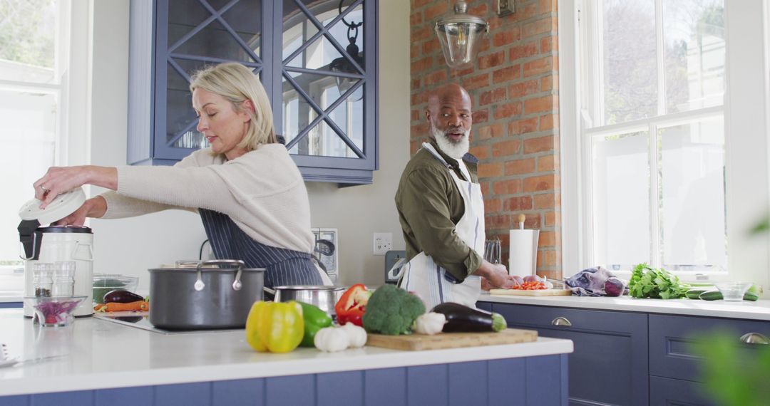 Biracial Senior Couple Joyfully Cooking Together in Home Kitchen - Free Images, Stock Photos and Pictures on Pikwizard.com