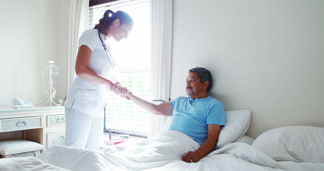 Nurse Holding Hand of Elderly Man in Hospital Bed - Free Images, Stock Photos and Pictures on Pikwizard.com