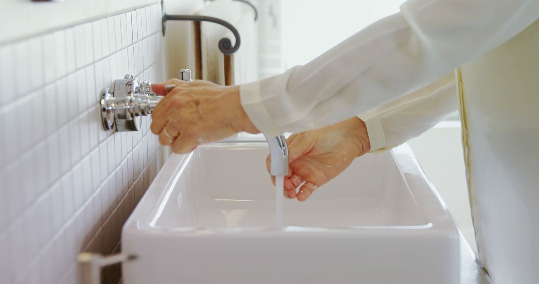 Elderly Woman Washing Hands in White Ceramic Sink - Free Images, Stock Photos and Pictures on Pikwizard.com