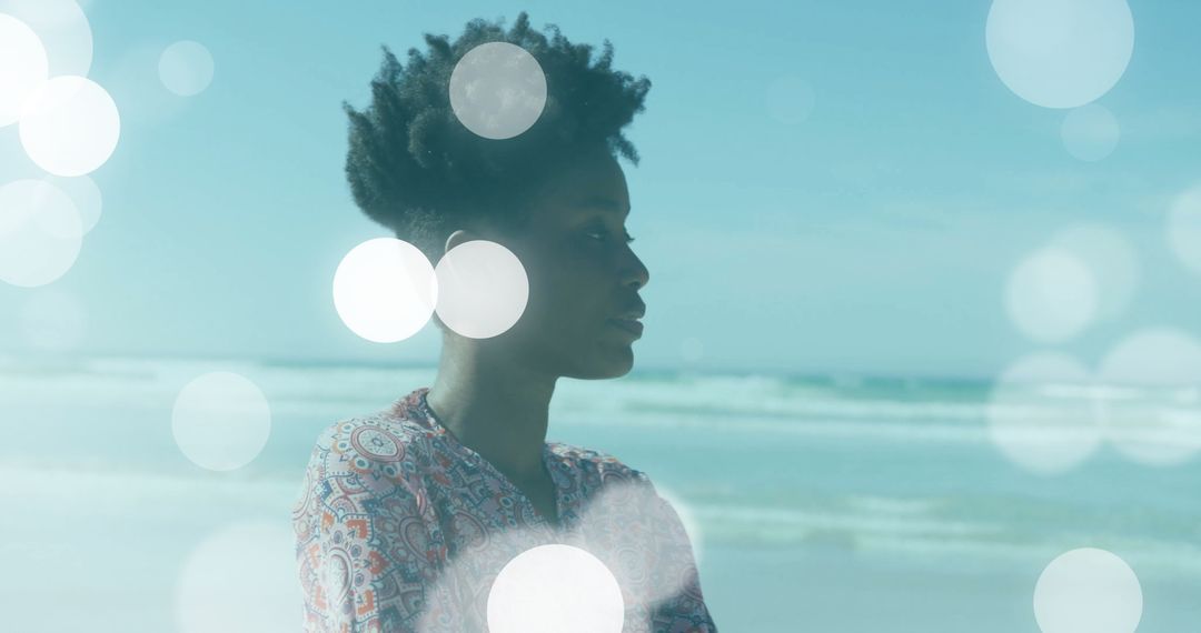 Woman in Paisley Blouse Gazing at Ocean with Bokeh Lights
