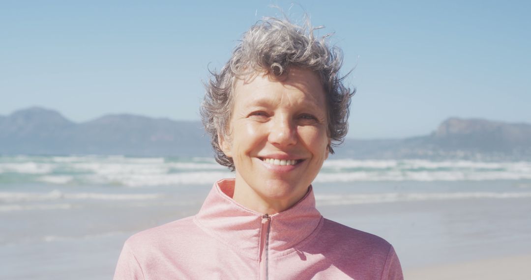 Portrait of happy senior caucasian woman wearing sports clothes smiling at beach - Free Images, Stock Photos and Pictures on Pikwizard.com