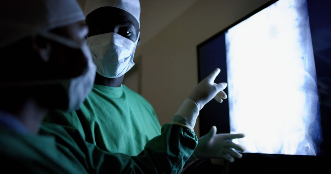 Doctors examining x-ray image pointing to spot of concern - Free Images, Stock Photos and Pictures on Pikwizard.com