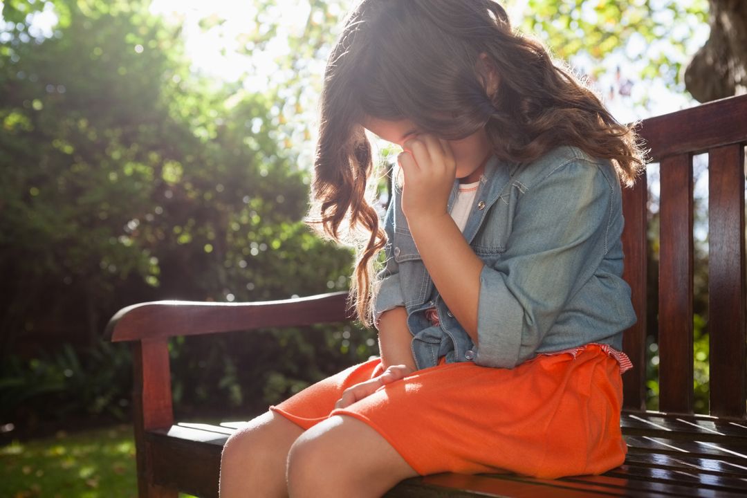 Upset girl crying while sitting on wooden bench - Free Images, Stock Photos and Pictures on Pikwizard.com