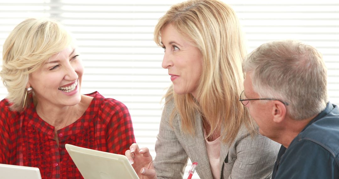 Business Professionals Engaging in Collaborative Discussion with Laptops