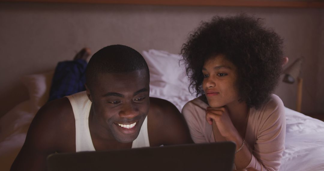 Couple Relaxing in Bed Enjoying Laptop in Cozy Home Setting