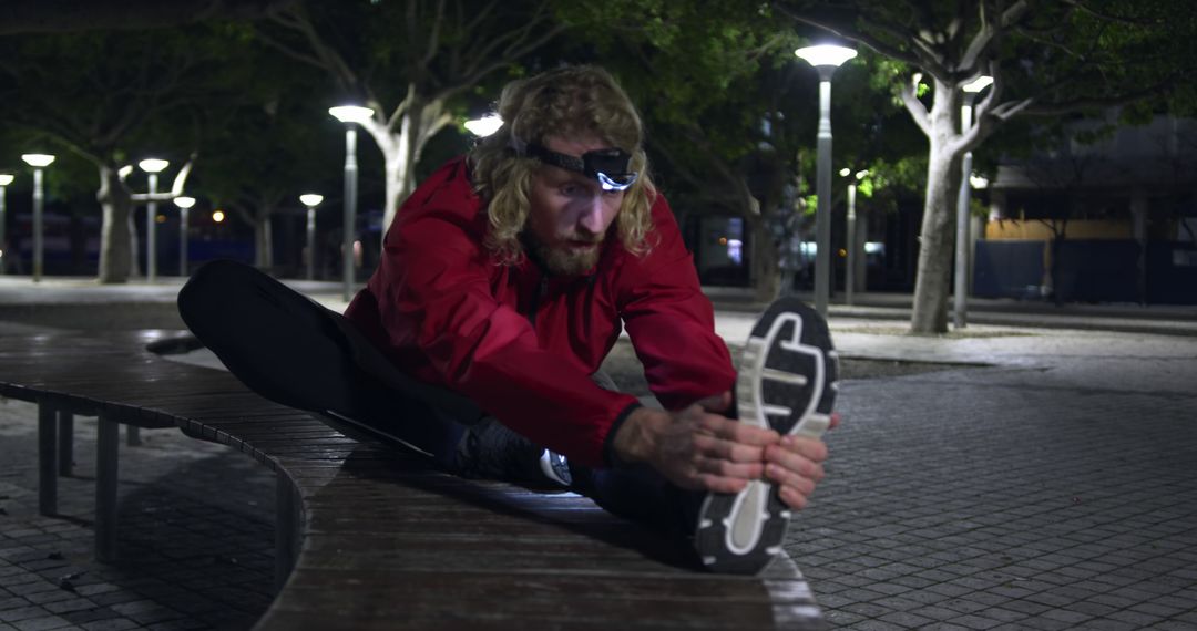 Man Stretching in City Park at Night With Headlamp - Free Images, Stock Photos and Pictures on Pikwizard.com