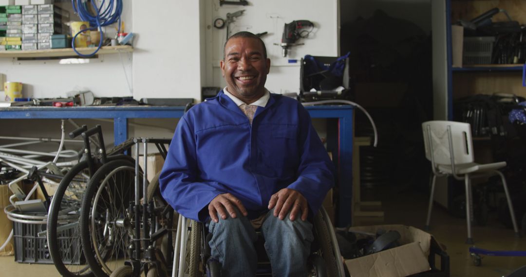 Smiling man in wheelchair in repair workshop - Free Images, Stock Photos and Pictures on Pikwizard.com