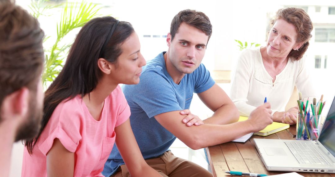 Young Adults Engaged in Mentoring Session with Teacher