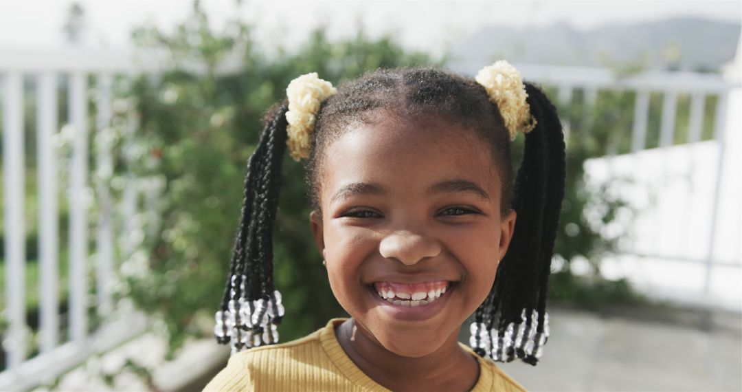 Smiling Little African American Girl with Pigtails Outdoors - Free Images, Stock Photos and Pictures on Pikwizard.com