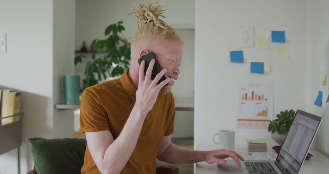 Businessman with Albinism on Phone Working from Home Using Laptop - Free Images, Stock Photos and Pictures on Pikwizard.com