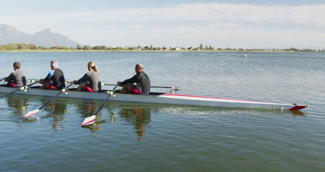 Team of Rowers Exercising in Calm Lake Waters - Free Images, Stock Photos and Pictures on Pikwizard.com