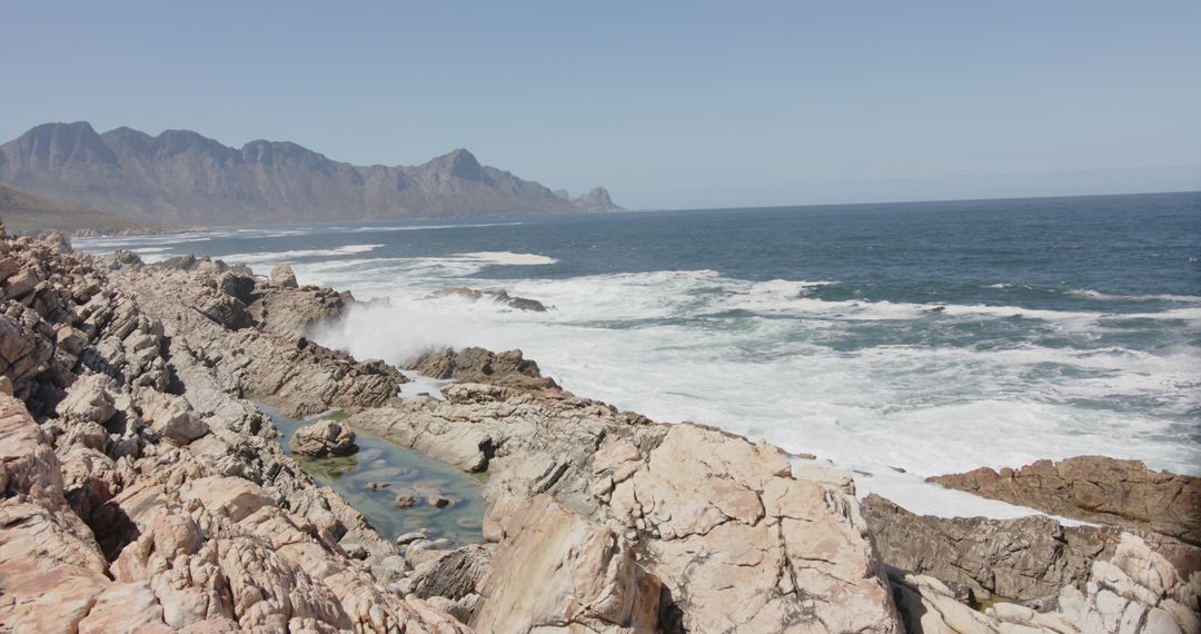 Rocky Ocean Shoreline with Scenic Mountain Range in Background - Free Images, Stock Photos and Pictures on Pikwizard.com